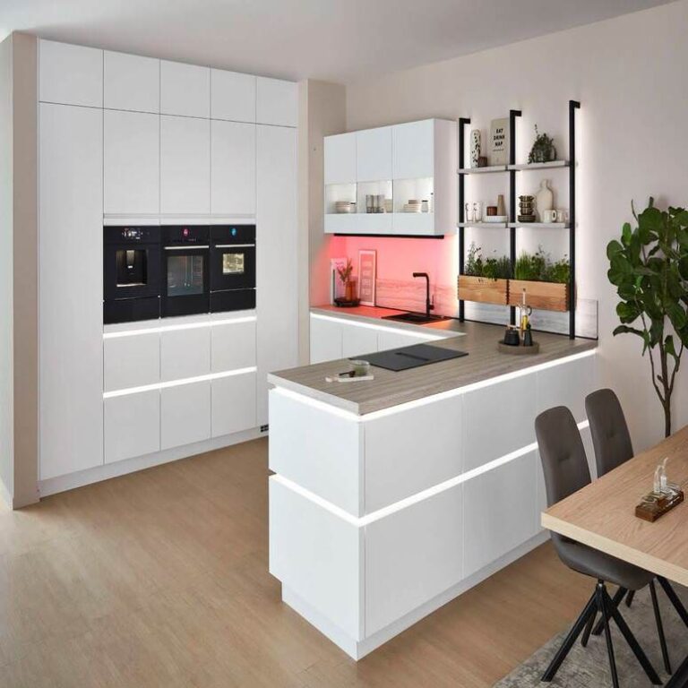 Weiße Küche mit beleuchteter Insel – Küchenangebote Paderborn Moderne grifflose Küche in Weiß mit beleuchteter Kochinsel und Kräuterregal